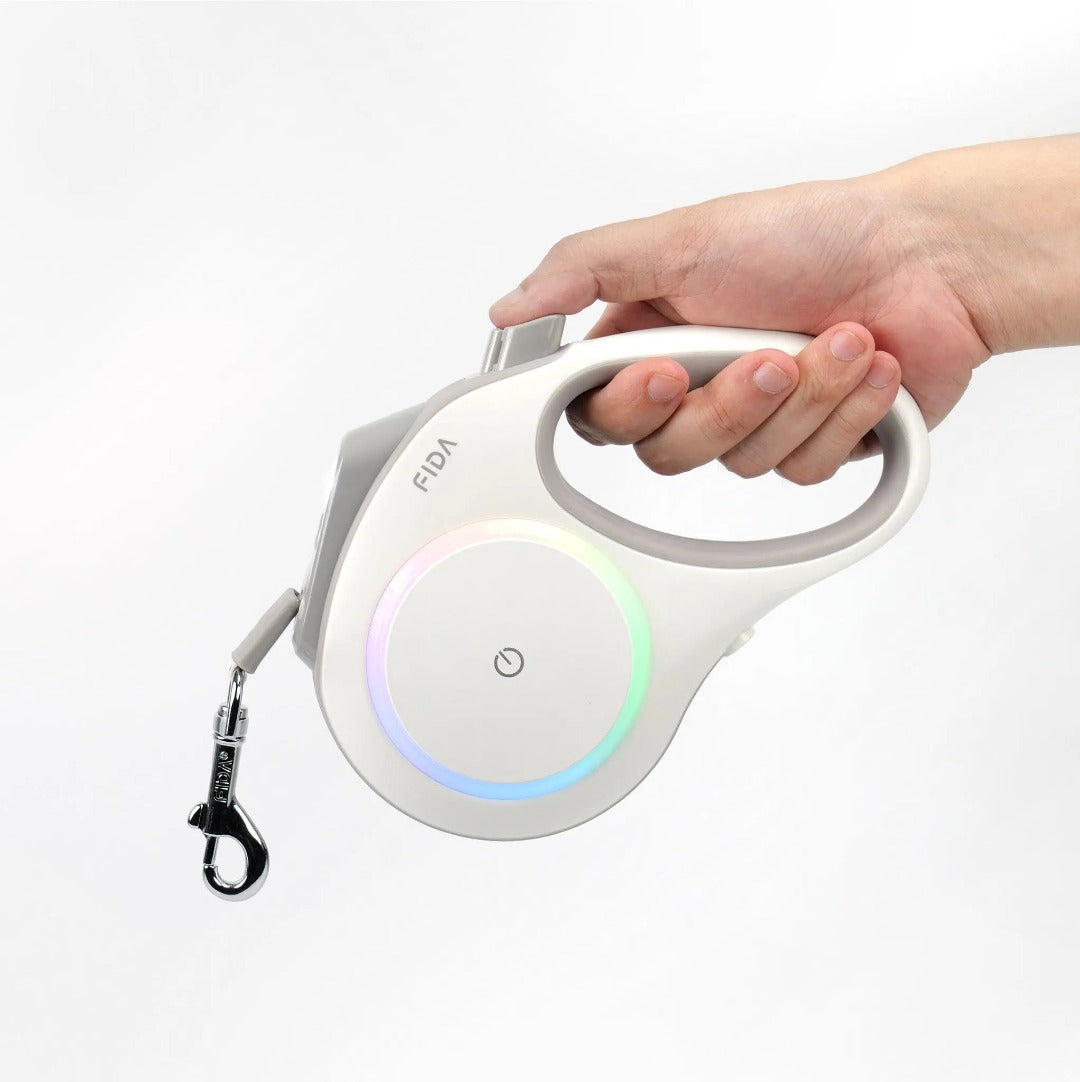 Hand holding the FIDA LED lighted retractable dog leash